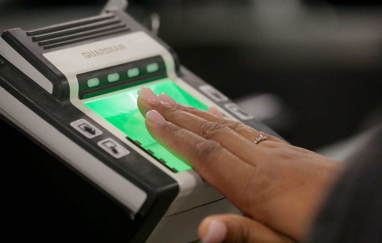 A person undergoing biometrics verification with the fingerprint scan machine.