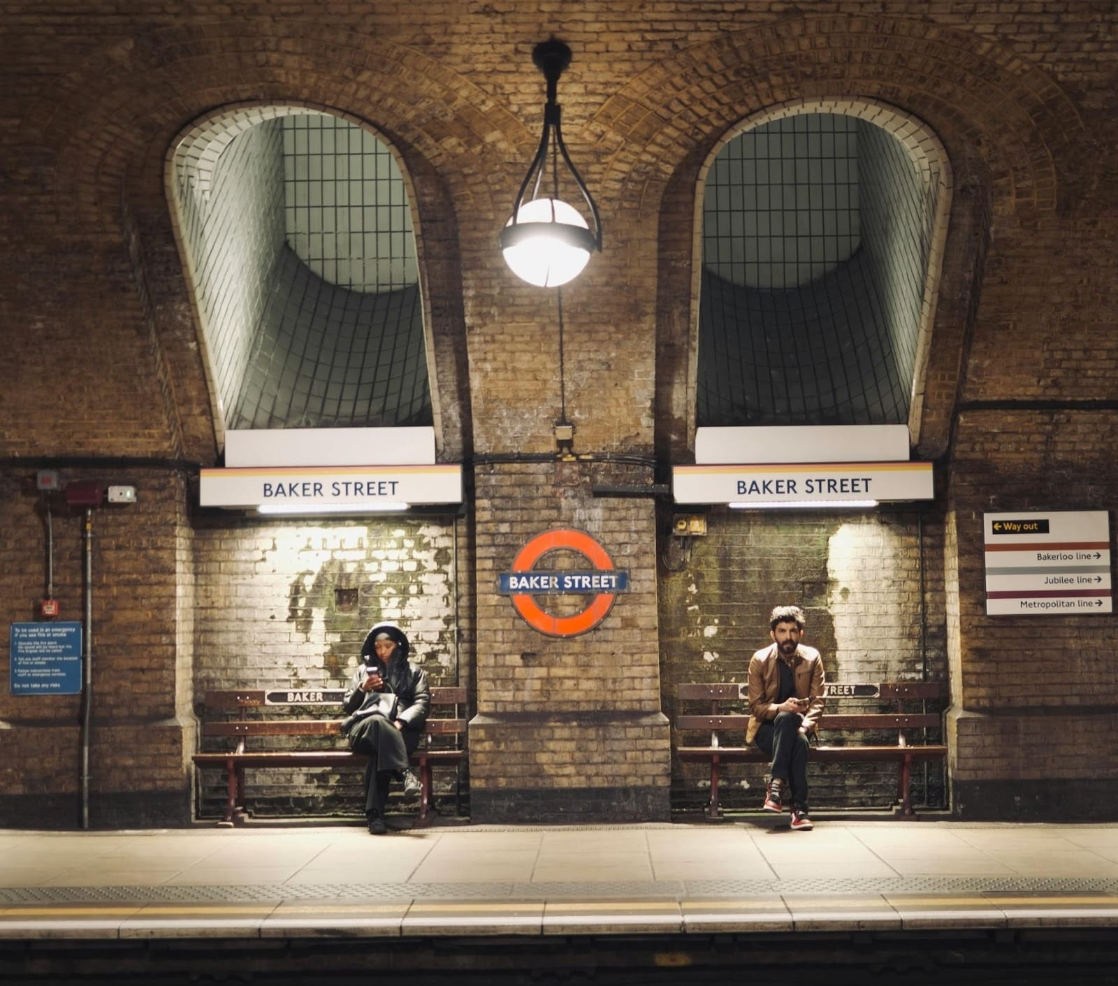 People sitting and waiting at Baker Street train station.